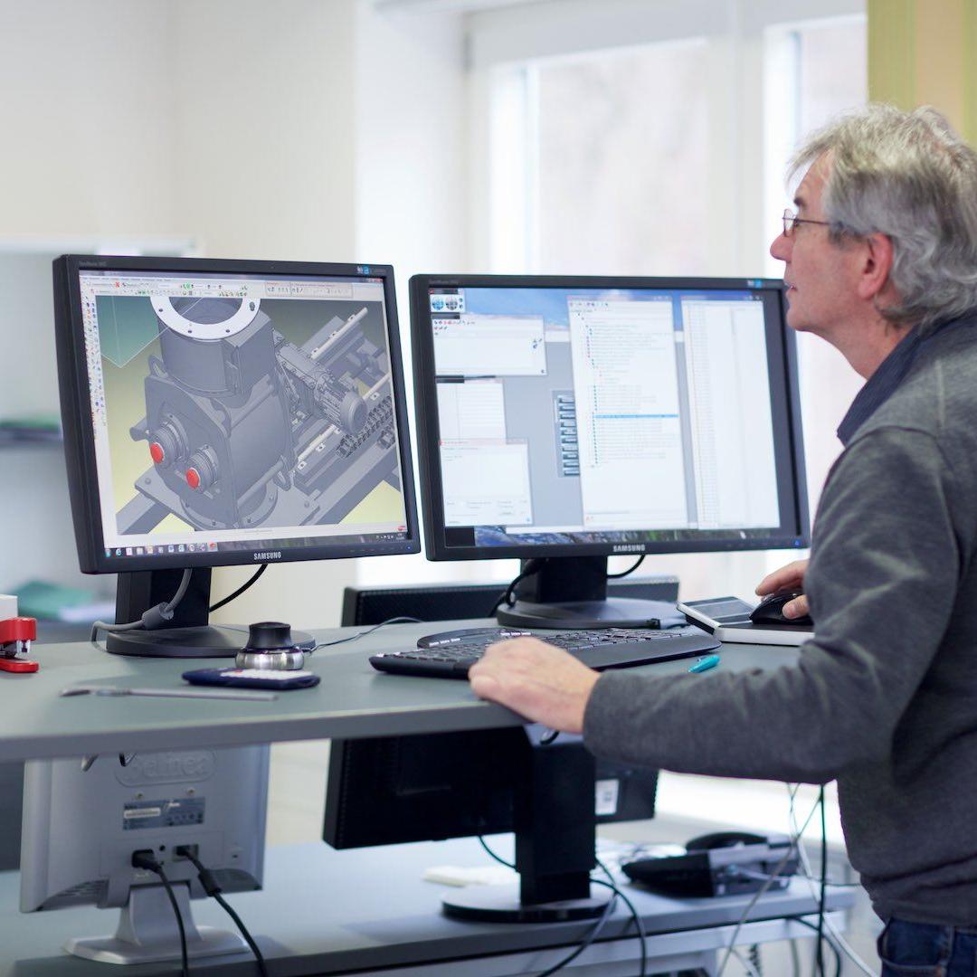 Ein Konstrukteur vor 2 Bildschirmen, arbeitet mit CAD-Software