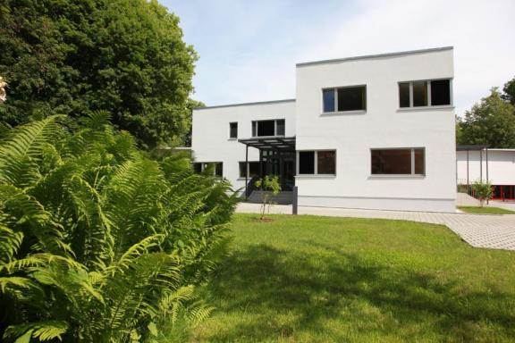 aktuelle Ansicht des Verwaltungsgebäudes bei JEHMLICH, grüner Farn im Vordergrund