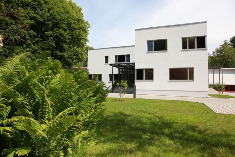 aktuelle Ansicht des Verwaltungsgebäudes bei JEHMLICH, grüner Farn im Vordergrund