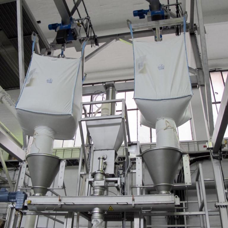 2 Big-Bag, hängend am Kran über einer Dosierschnecke zur Produktaufgabe