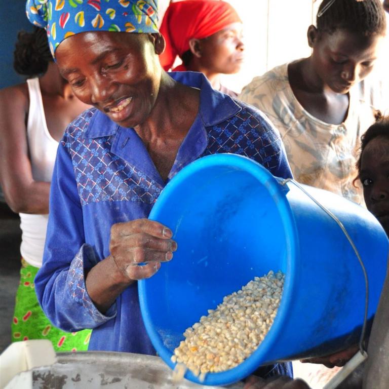 Woman Feeding Corn Into Jehmlich corn Mill